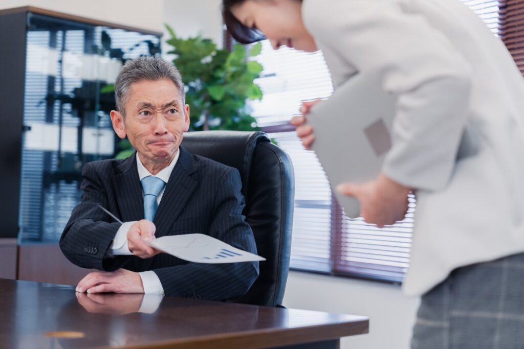 気難しい顔をして部下に話しかける男性