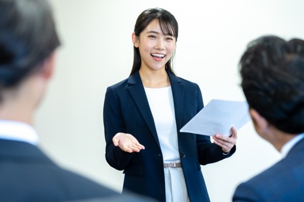 女性　人前　説明　プレゼン　発表　笑顔