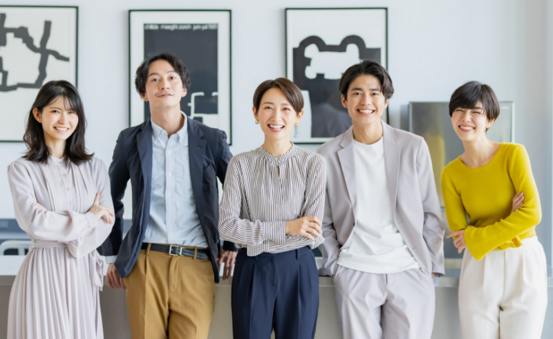 笑顔で立っている5人の男女